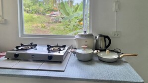 A kitchen with a gas stove, a kettle, and a pot on a countertop. - Ferm's Residence B-spacious Apartment With Fast Wifi (Dauis)