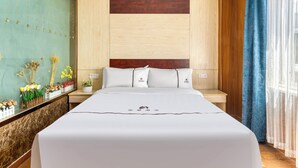 Ein Hotelzimmer mit einem großen Bett, Holzwandverkleidung, einem Marmornachttisch und Blick auf die Stadt durch transparente Vorhänge.