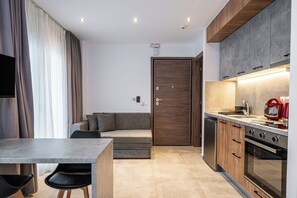 Apartamento Deluxe | Cocina privada | Frigorífico, horno, placa de cocina y utensilios de cocina
