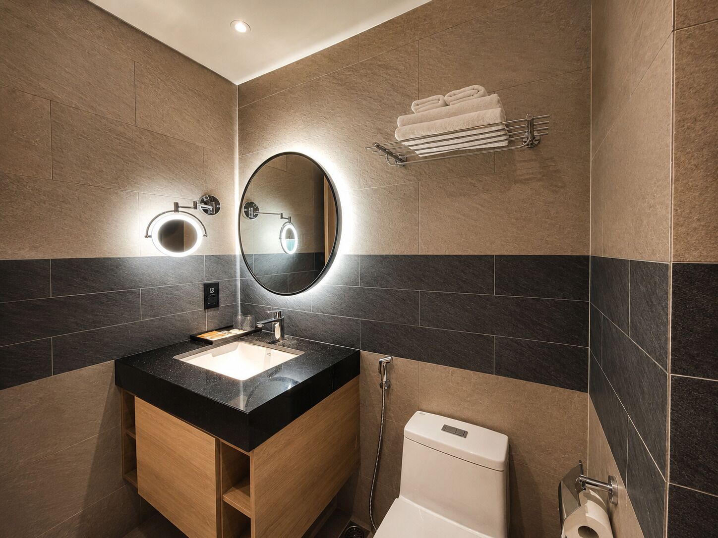 A modern bathroom with a sink, mirror, towel rack, and toilet.