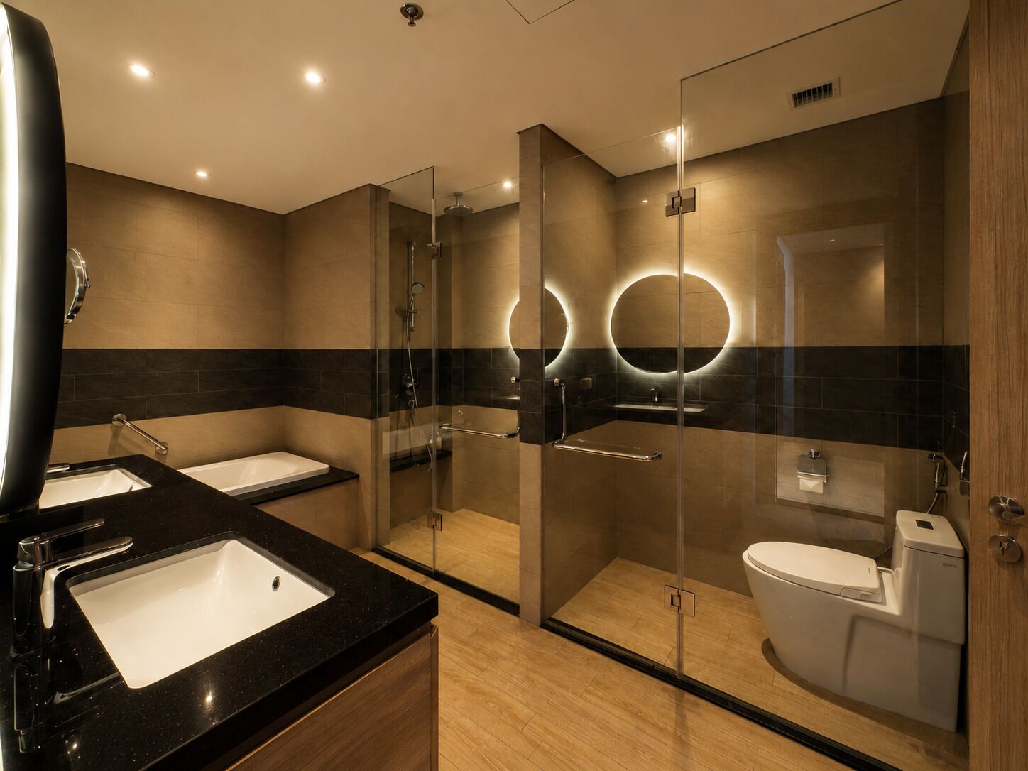 Un bagno moderno con doccia vetrata, due lavabi e il water.