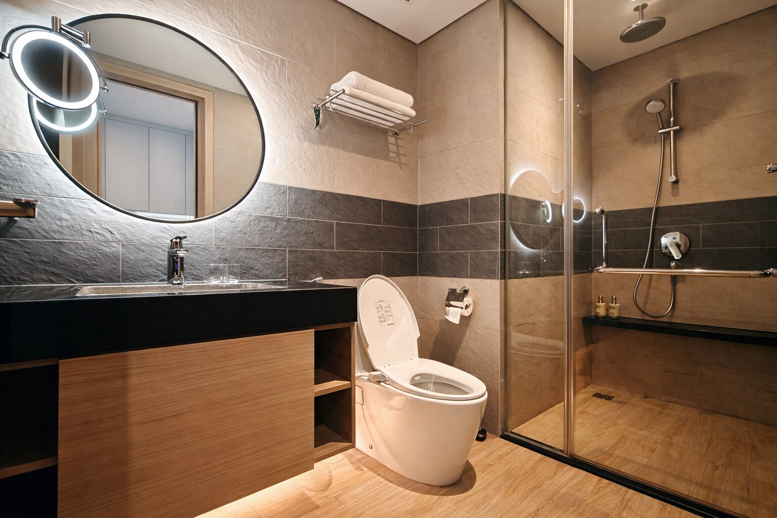 A modern bathroom with a toilet, sink, and shower.