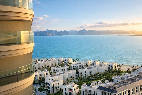 A coastal residential area with modern architecture, a large body of water, and distant mountains.