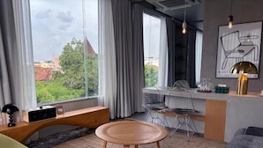 Een moderne woonkamer met een ronde houten tafel, een bank en een eethoek met stoelen.