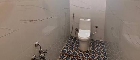 A small bathroom with a toilet, a shower, and a sink.