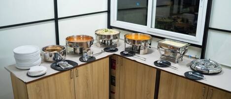 A kitchen with multiple serving stations, each with a variety of dishes and utensils.
