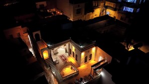 Un patio con una zona de estar central, una escalera y una pequeña piscina.