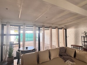 A room with a beige sofa, a small round table, and a potted plant. - M’Khaya , your home away from home , close to all amenities in Johannesburg (Johannesburg)