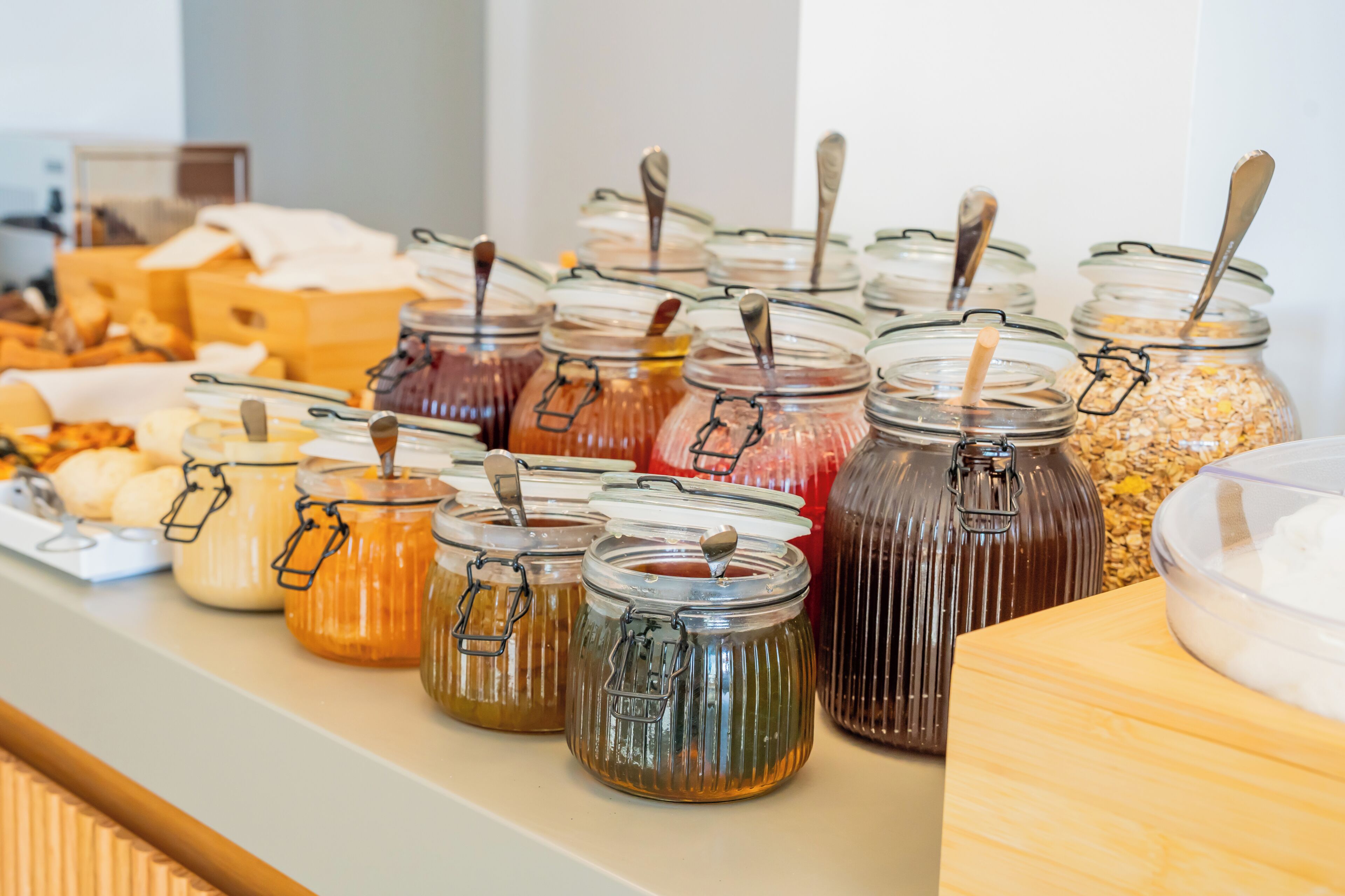 Un bufé con diversos alimentos en recipientes de vidrio.