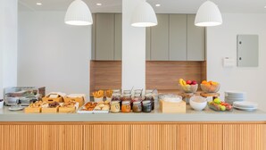 A buffet setup with various food items and condiments. - Ramnus Karpathos Suites (Karpathos)
