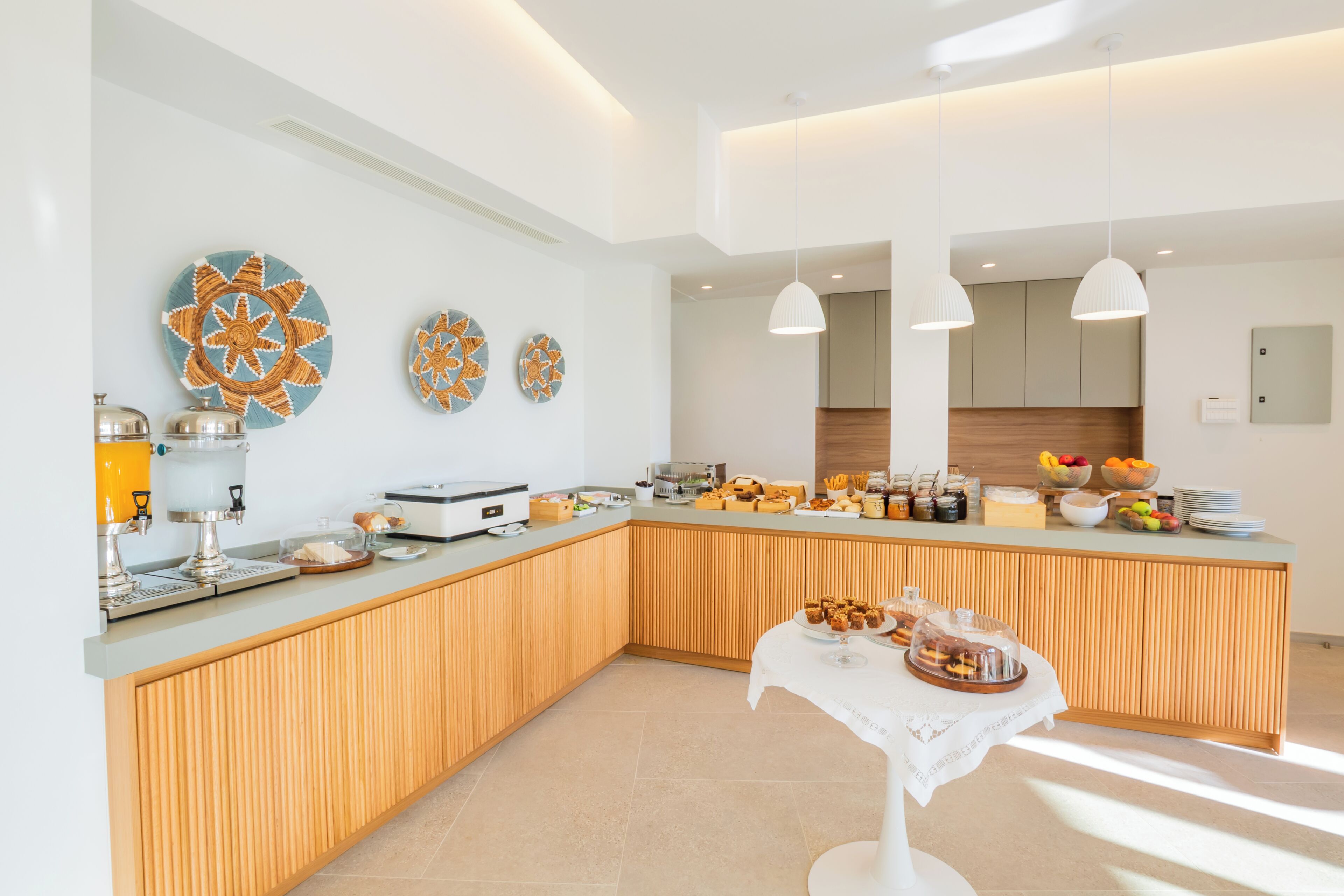 A modern kitchen with a wooden island, a buffet setup, and decorative plates on the wall.