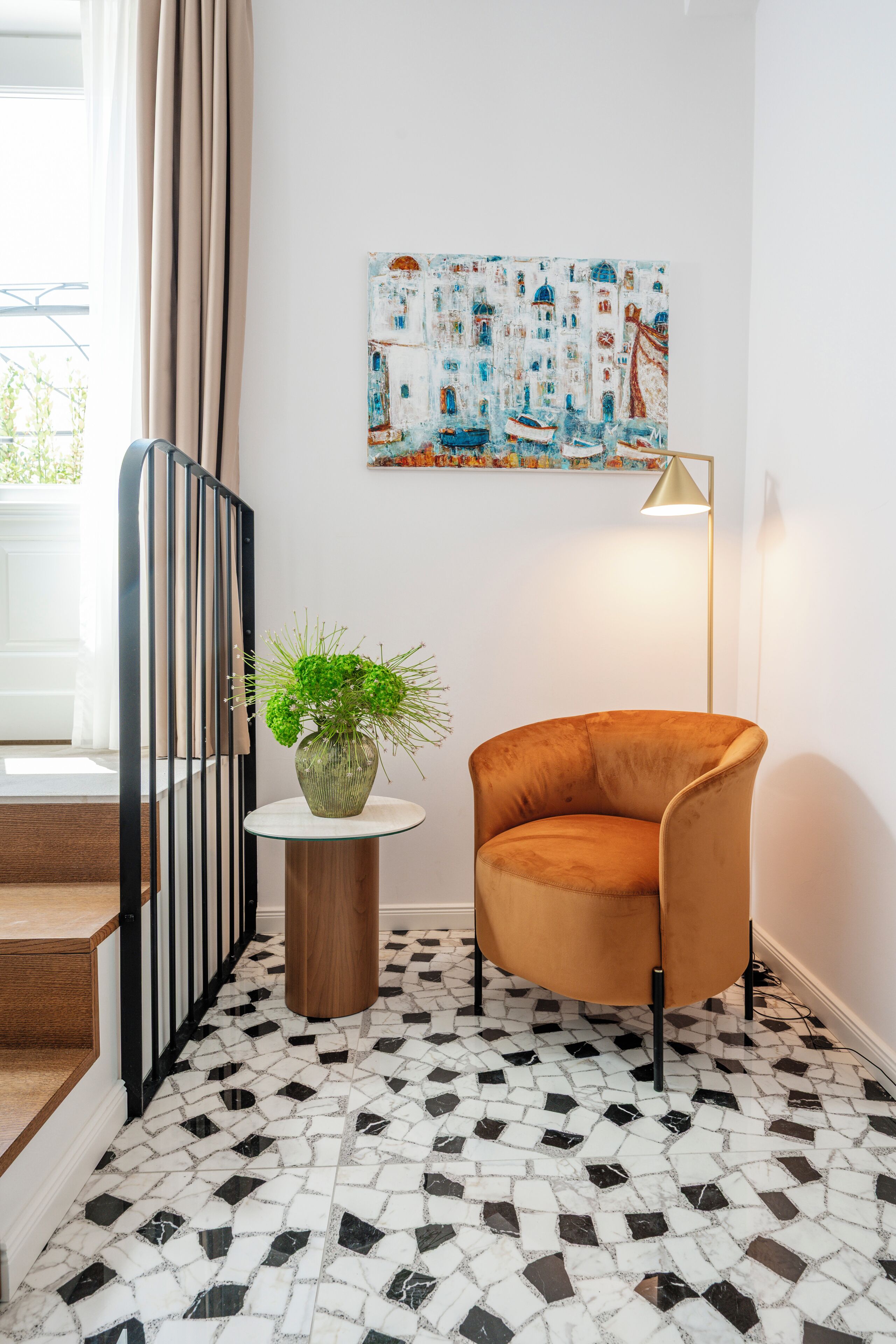 A room with a tiled floor, a plant on a small table, a chair, a painting on the wall, and a floor lamp.