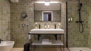 A modern bathroom with a white sink, mirror, and shower.
