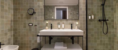 Un baño moderno con lavamanos, espejo y ducha blancos.