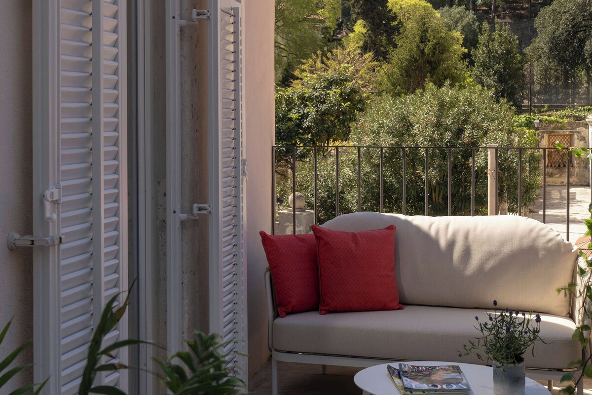 Un espace extérieur aménagé avec un canapé, une petite table et une plante en pot.
