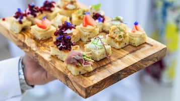 A wooden board with various food items, likely for a catering event.