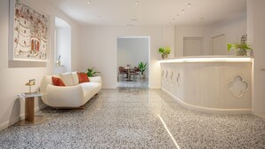Un interno moderno con un divano bianco, una reception e un'area pranzo.