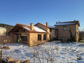 Ein zweistöckiges Haus mit Ziegeldach, Schornstein und Satellitenschüssel.