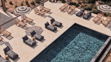 A pool area with lounge chairs and umbrellas.