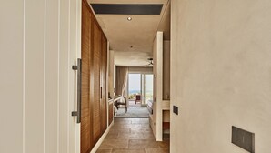 Un couloir donnant sur l’extérieur, une chaise et un lit.