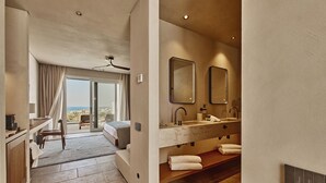 Une salle de bain moderne avec un grand lavabo, deux miroirs et une vue sur la mer.