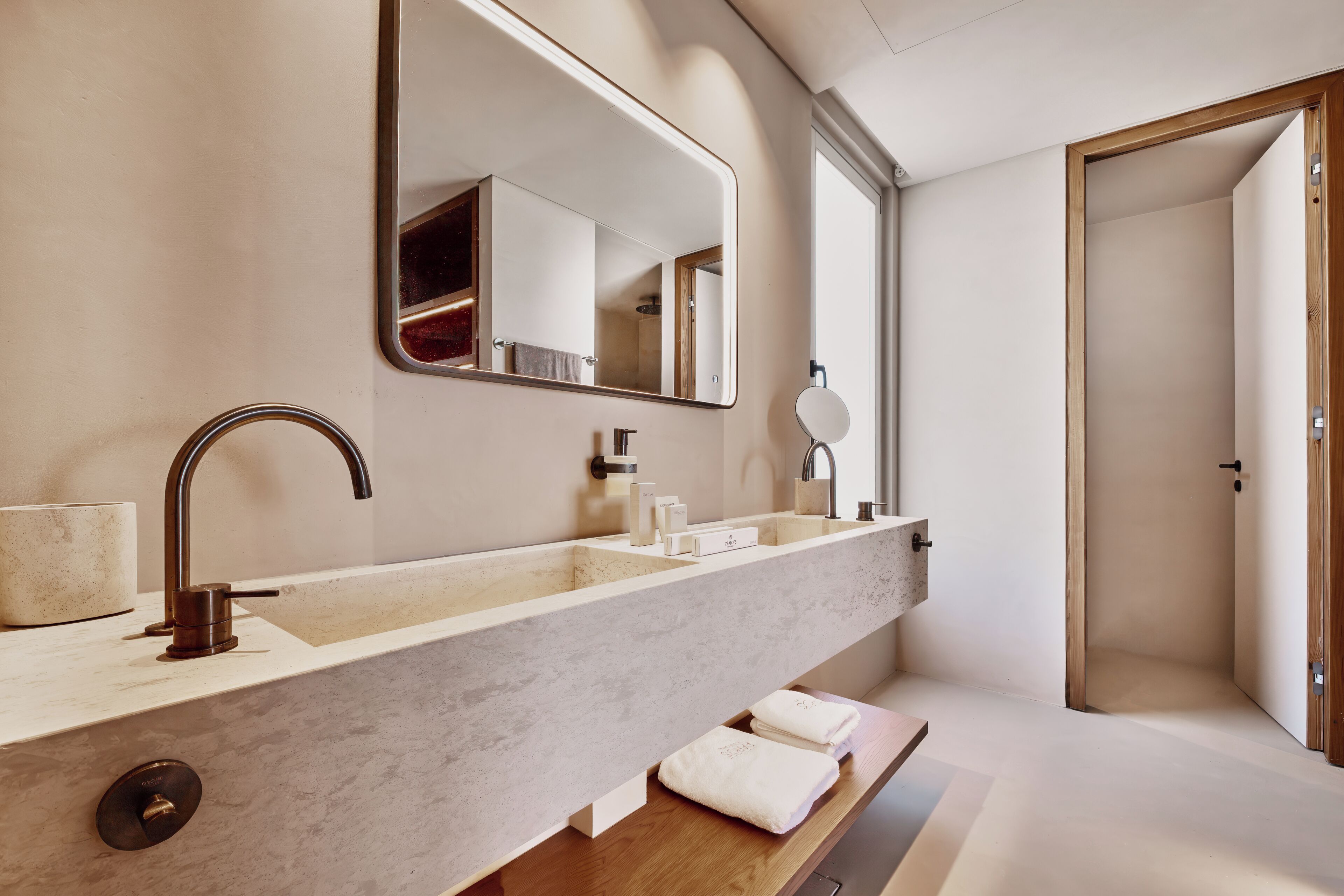 A modern bathroom with a large mirror, a sink, and a shower area.