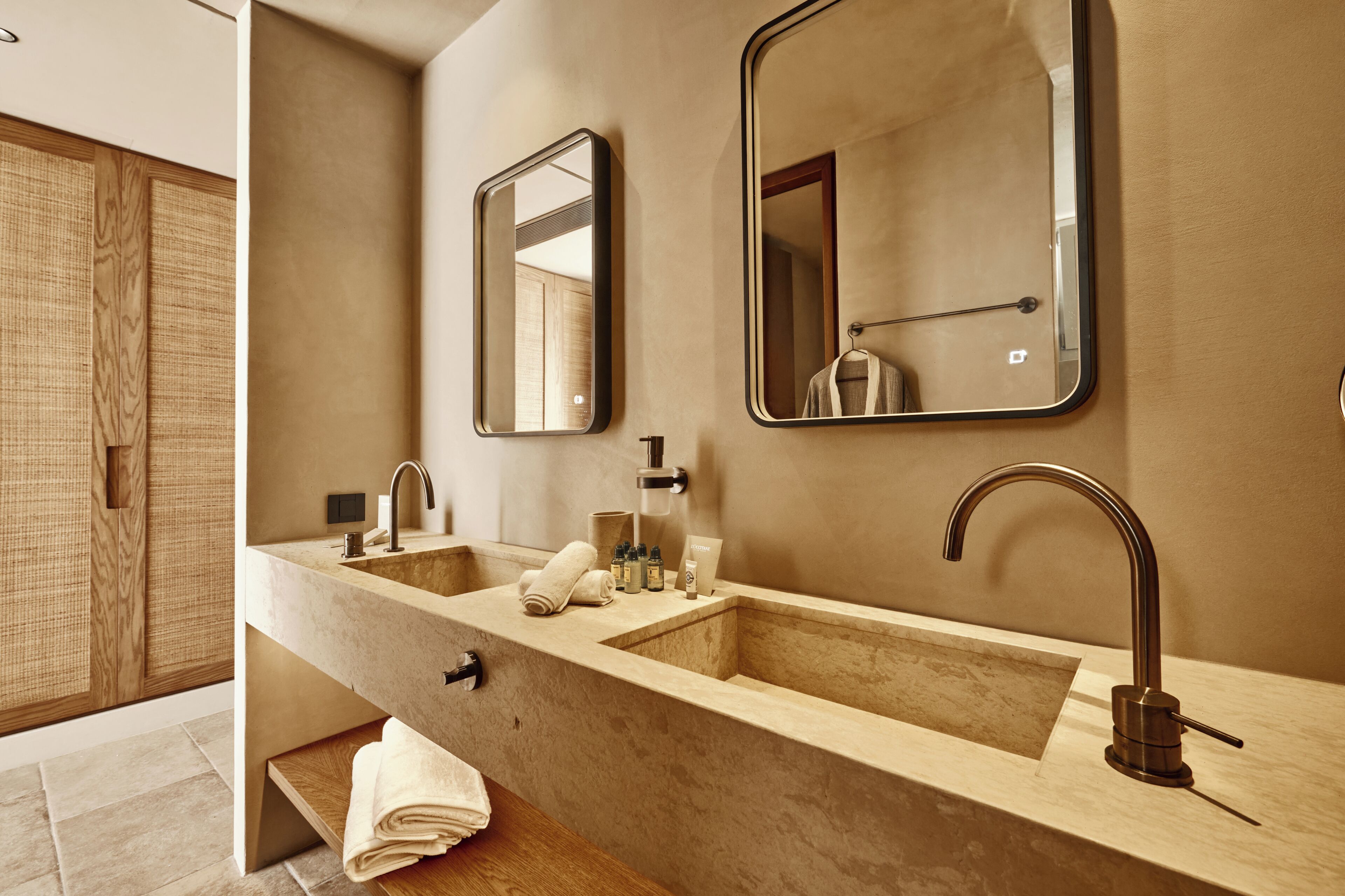 A modern bathroom with a double sink, a large mirror, and a towel rack.