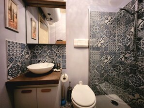 Un baño con lavamanos, inodoro y ducha.