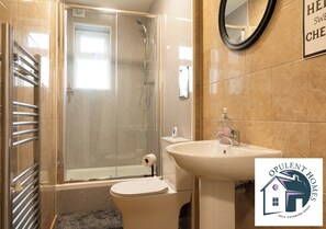 Een badkamer met een douchecabine, toilet, wastafel en handdoekhouder.