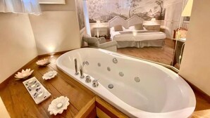 Ein Badezimmer mit einer großen Badewanne, einem Holzbadezimmerschrank und dekorativen, lotusblütenförmigen Seifenschalen.