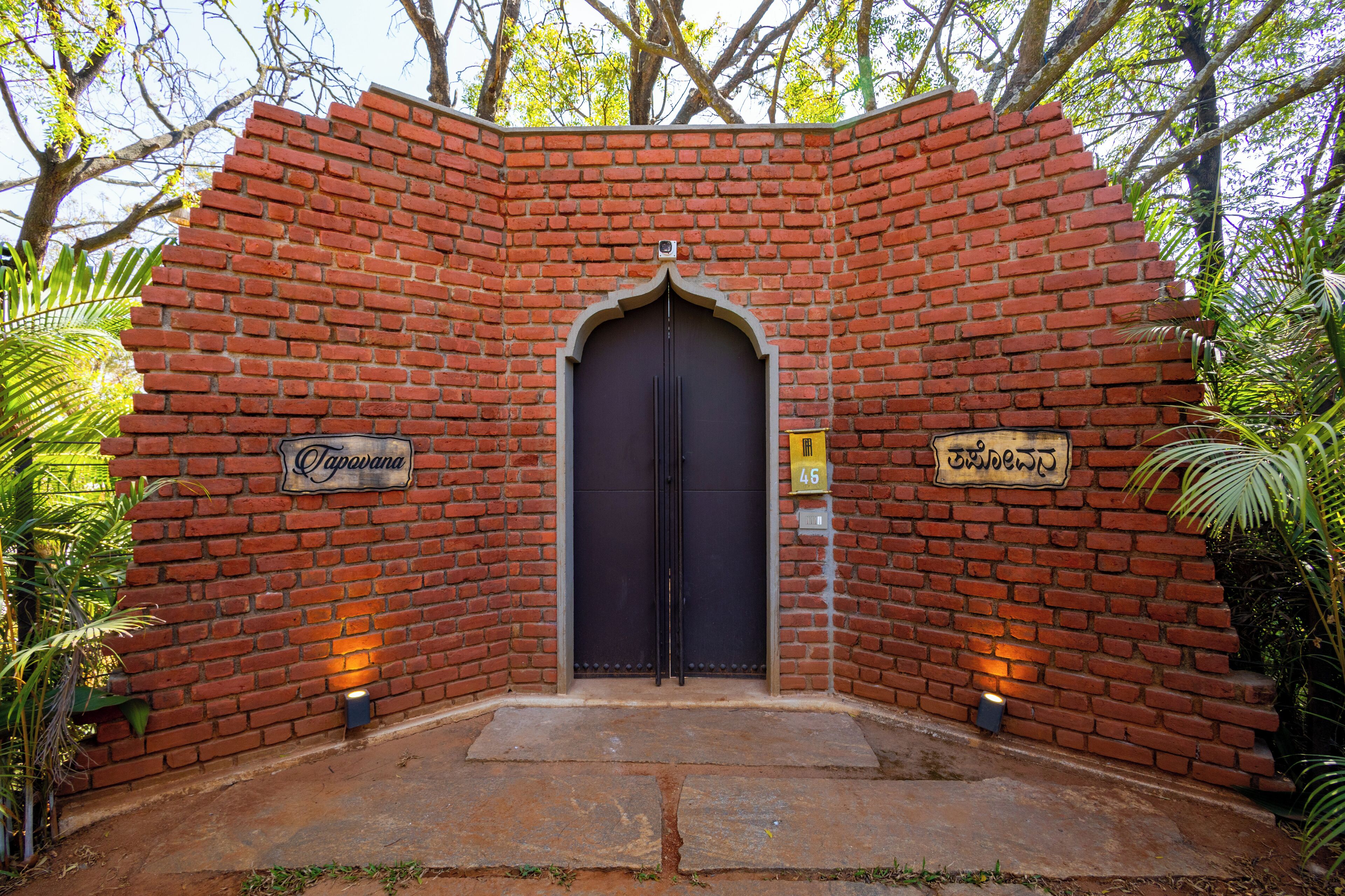 A brick wall with a dark door and two illuminated signs.