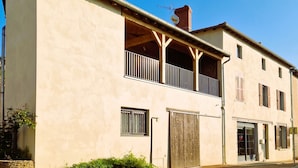 Un edificio di due piani con un balcone, un'autorimessa e un'antenna parabolica.