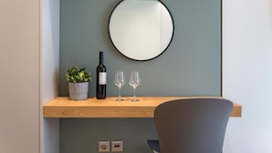 A modern room with a wooden shelf holding a wine bottle, two glasses, and a potted plant. - Athena Urban Retreat Apartment (Athens)