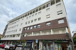 A multi-story building with a ground-floor pharmacy named 'Farmacia Jublin.' - GuestHost - Darsena: A Bright and Cozy Apartment   (Ferrara)
