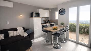 A modern apartment with a living area, kitchen, and dining space.