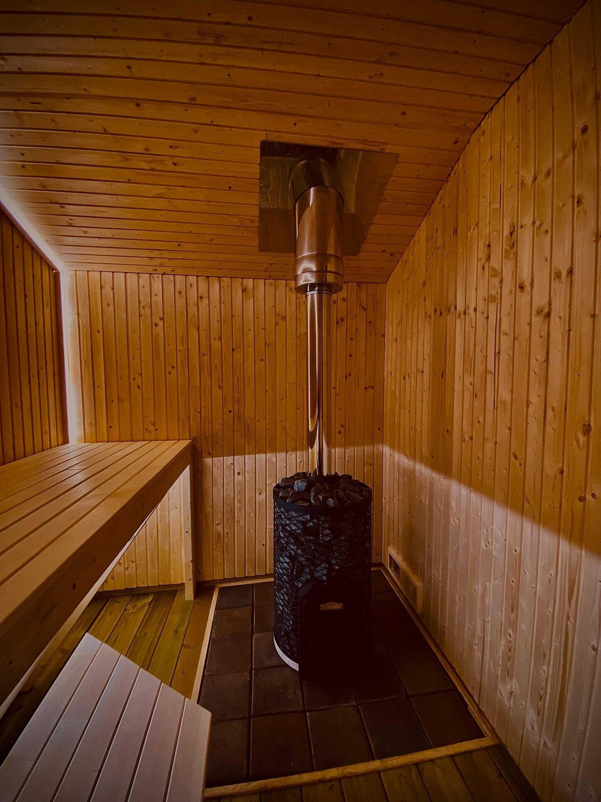 Sauna, jonka seinät ja penkit ovat tehty puusta.