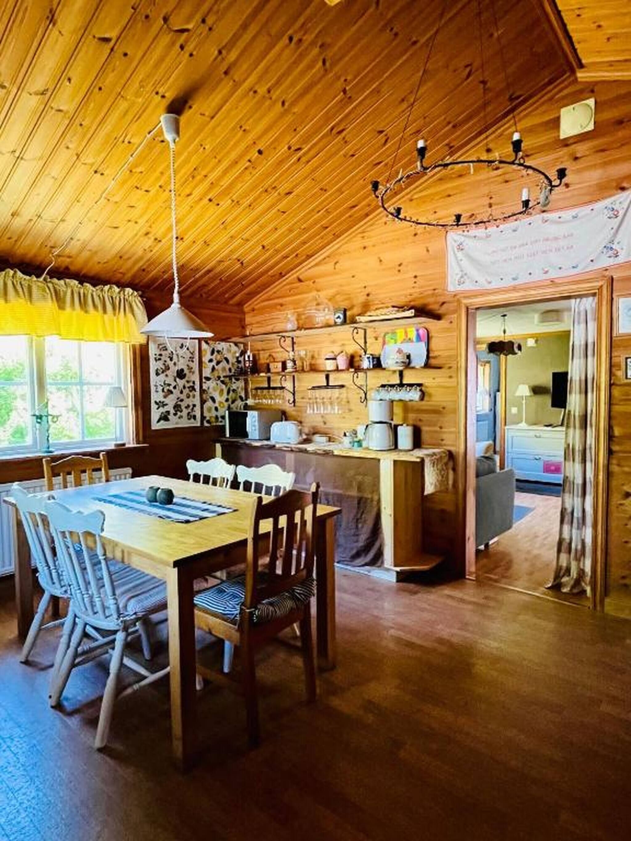 Un intérieur en bois comprenant un coin repas, une cuisine et un espace de vie chaleureux.