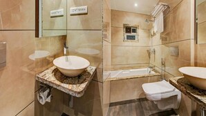 Casa de banho moderna com um espelho grande, duas pias, uma banheira e um chuveiro.