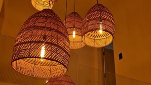 A modern interior with multiple spherical wicker pendant lights hanging from the ceiling. - DAR EL NOUR | Villa pied dans l'eau | 130 m² | Rooftop avec vue exceptionnelle (Korba)