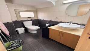 Un baño pequeño con inodoro, lavamanos y espejo.