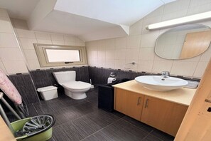 Ein kleines Badezimmer mit Toilette, Waschbecken und Spiegel.