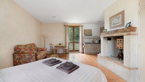 Een slaapkamer met een bed, een slaapbank, een bureau en een keukenhoek.