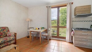 Een keuken met een eettafel, stoelen, een bank en een kast.