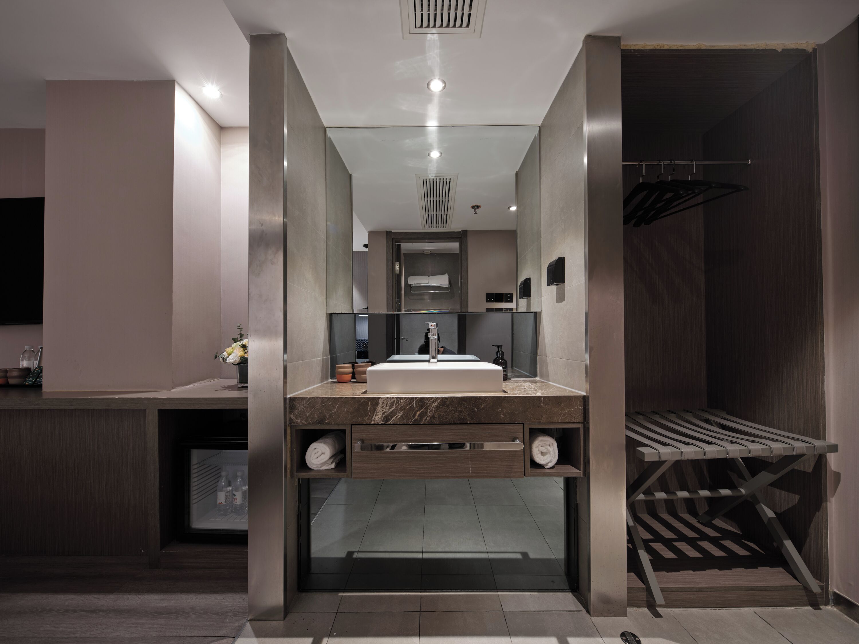 A modern bathroom with a central sink, a mirror, and a shower area.