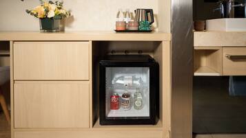 A kitchen with a refrigerator, a sink, and a countertop with a vase of flowers.