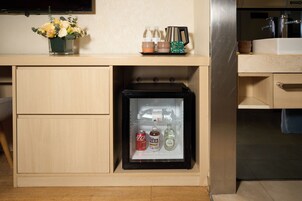 A kitchen with a refrigerator, a sink, and a countertop with a vase of flowers.