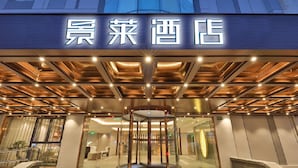A hotel entrance with a revolving door, a glass facade, and a sign with Chinese characters. - JL Hotel Shanghai LujiazuiOriental Pearl (Shanghai)