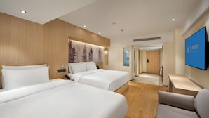 A hotel room with two beds, a flat-screen TV, a desk, and a sofa. - JL Hotel Shanghai LujiazuiOriental Pearl (Shanghai)
