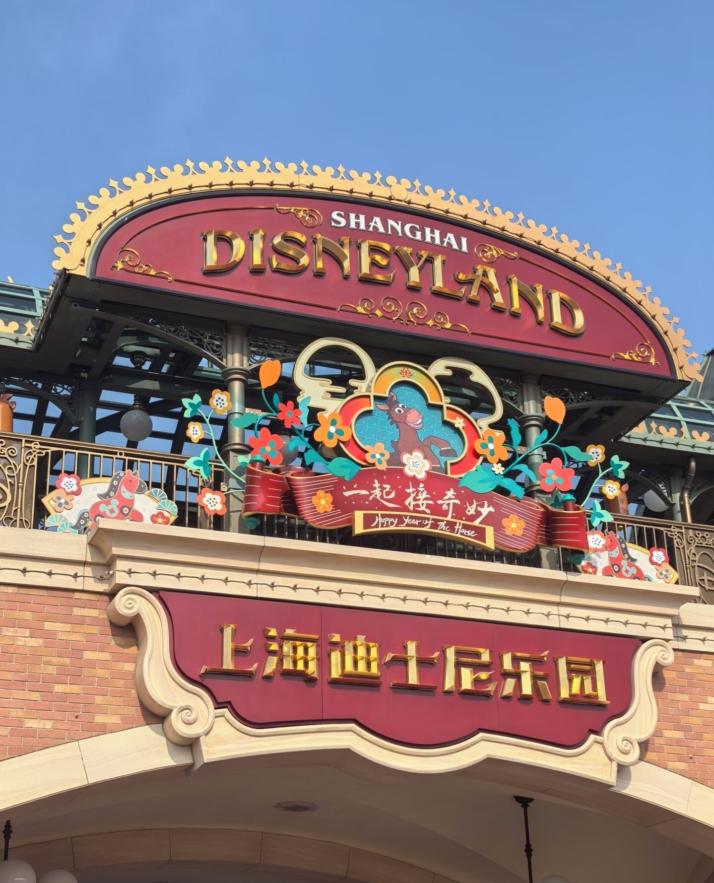 The Shanghai Disneyland entrance sign with decorative elements and the name 'Shanghai Disneyland' prominently displayed.
