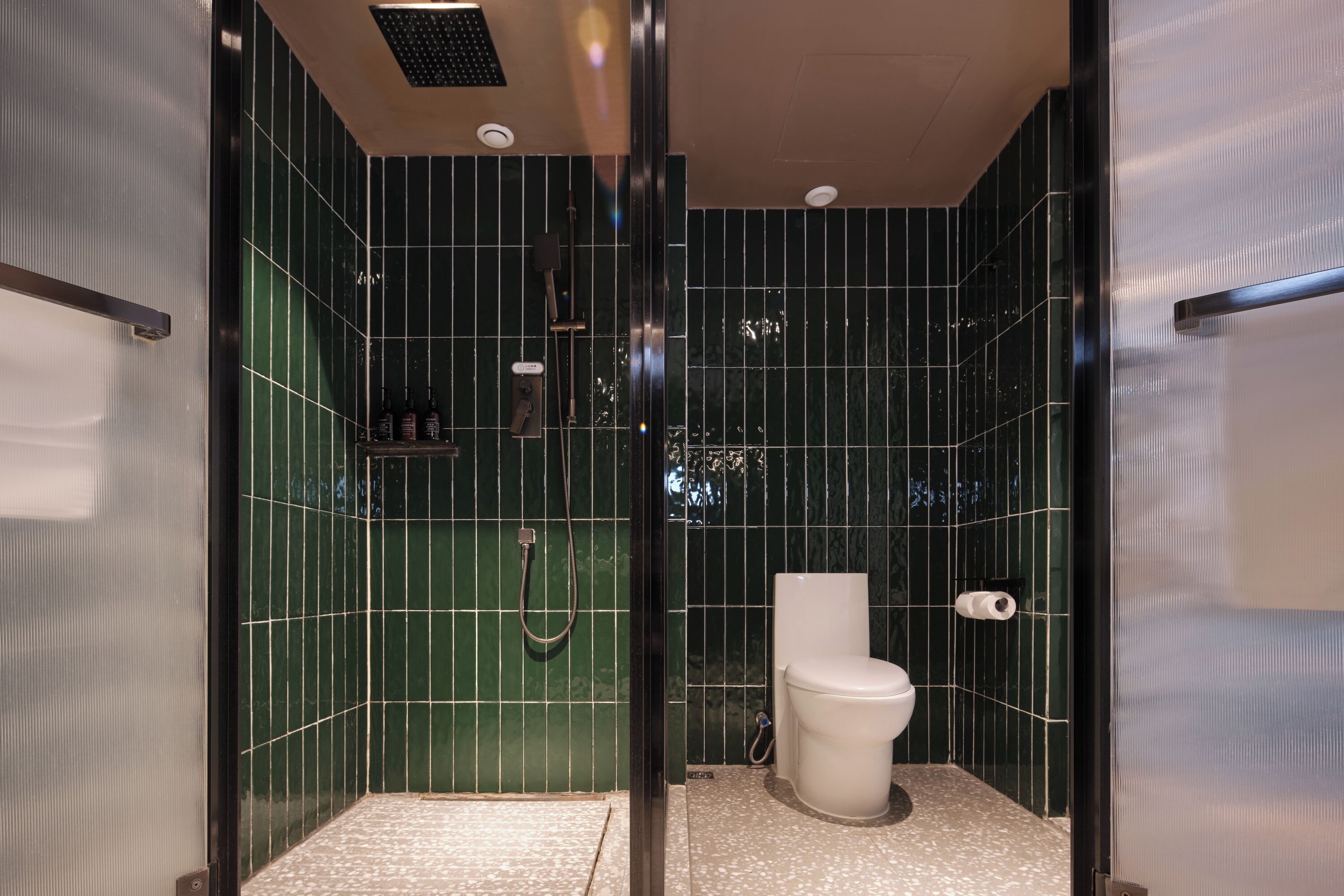 A modern bathroom with a shower, toilet, and a glass-enclosed shower area.